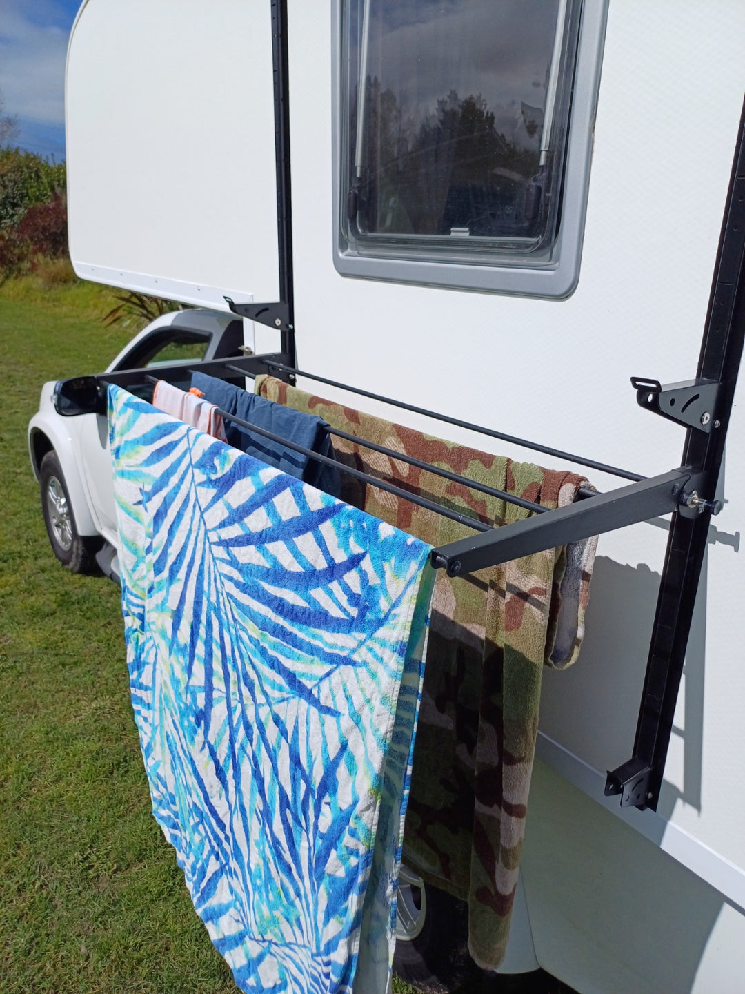 Side mount cargo racks for motorhomes and caravans